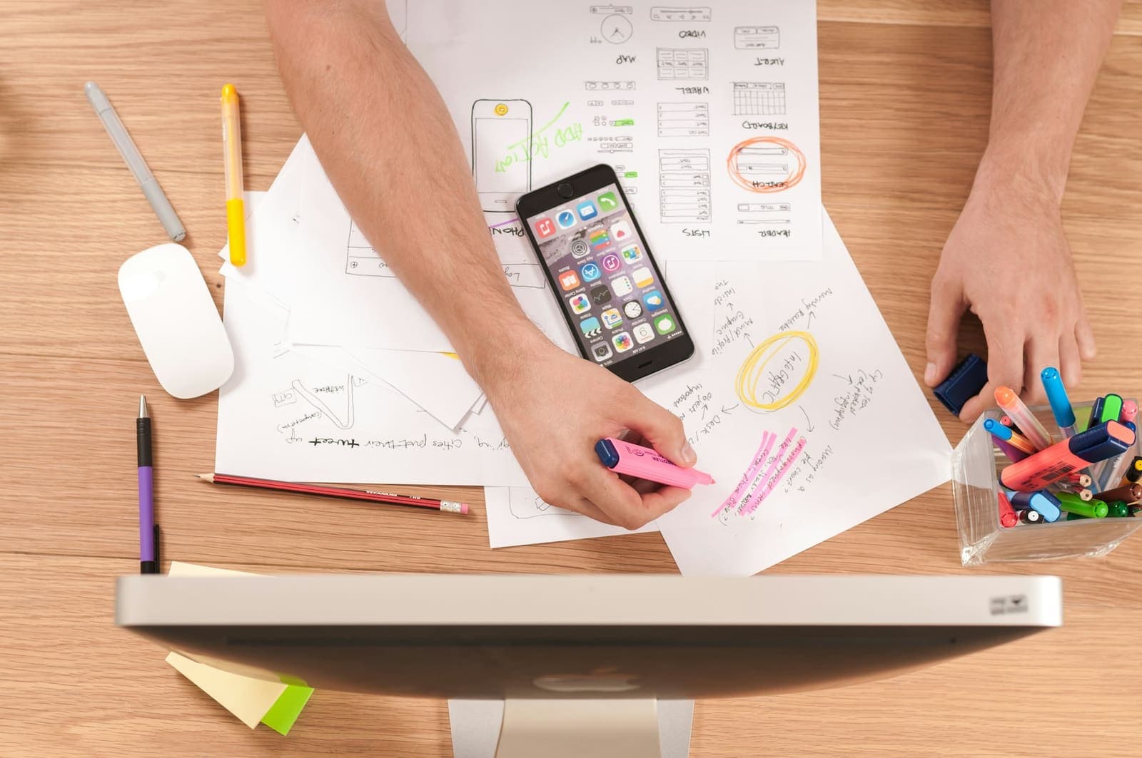 Marketer planning a social media advertising campaign with sketches and a smartphone