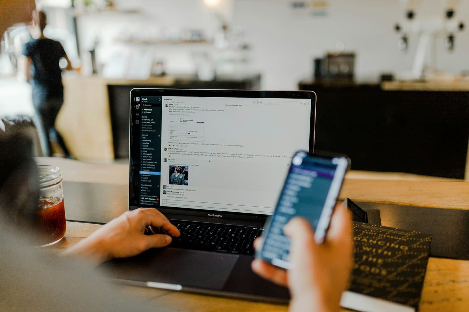 Person browsing a responsive website on a smartphone next to a laptop